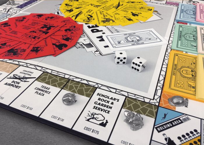 Board game close-up showing dice, cards, money